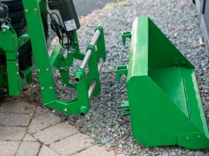 Close up of the LGM QORE Utility Attachment showing the bucket sitting in front of the universal mount plate.